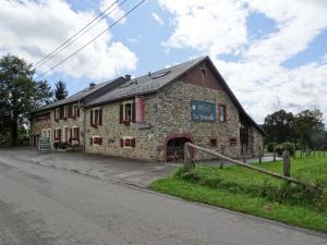 un vecchio edificio in pietra sul lato di una strada di La Trouvaille a Waimes