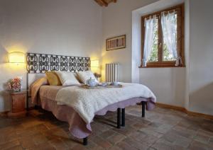 a bedroom with a bed with a blanket and a window at Podere Scaluccia in Impruneta