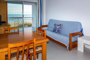 a living room with a table and a couch and a dining room with a view at Irtaplaya 310 in Alcossebre