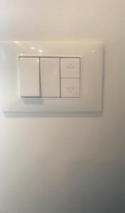 a white lightswitch on a white wall at Bari Lory’s Home in Bari