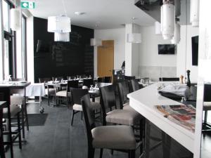 a dining room with tables and chairs and a chalkboard at Motel Chute des Pères in Dolbeau