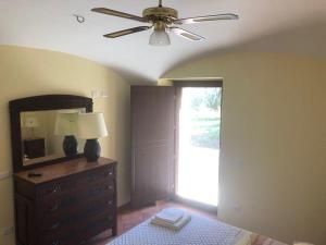 a bedroom with a ceiling fan and a dresser with a mirror at La Sorgente Alta in Rocchetta a Volturno