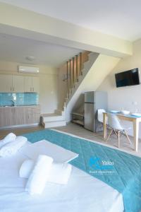 a bedroom with a large white bed and a table at Yalos Beach Maisonettes in Skala Sotiros