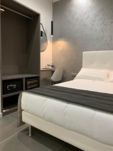 a bedroom with a white bed and a television at ApartHotel Bossi in Milan