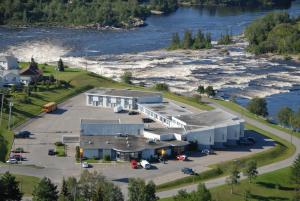 an aerial view of a building next to a river at Motel Chute des Pères in Dolbeau