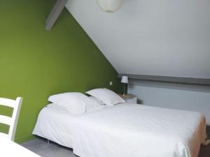 a bedroom with a white bed with a green wall at Etage privatif in Tarbes