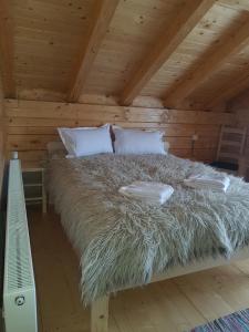 Una cama con dos almohadas en una cabaña en Tulean Cabin en Săcel