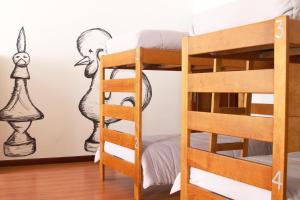 a bedroom with bunk beds and a wall with a drawing on the wall at Hostel 2300 Thomar in Tomar