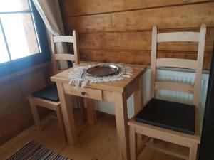 a small table and two chairs in a room at Tulean Cabin in Săcel