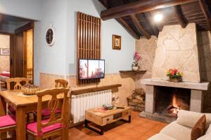 a living room with a table and a fireplace at Casa Rural El Berrueco in Robledillo