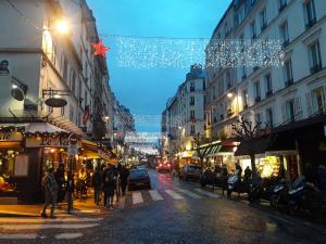 a busy city street at night with christmas lights at Romantic Tiny House inside Montmartre in Paris