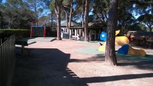 een speeltuin in een park met een boom bij Résidence Valescure in Saint-Raphaël