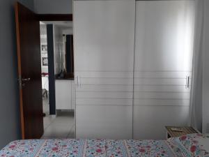 1 dormitorio con 1 cama y armario blanco grande en Flat Atlântico Tambaú, en João Pessoa
