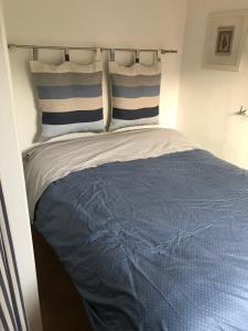 a bed with blue and white sheets and pillows at Appartamento La casa di Chiara in Porto Azzurro