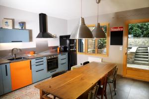 a kitchen with a wooden table and a dining room at Maison des Orfèvres in Arbois