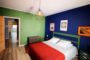 1 dormitorio con paredes azules y verdes y 1 cama en Maison des Orfèvres, en Arbois