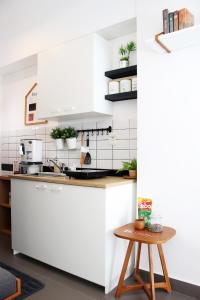 a kitchen with white cabinets and a wooden stool at Scandinavian Asia Afrika in Bandung