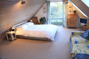 a bedroom with a large white bed and a window at Brook Barn in Selham