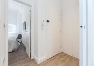 - une chambre blanche avec des placards blancs et un miroir dans l'établissement White Piccadilly Luxury Flat, à Londres