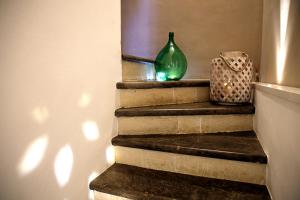 a green vase sitting on top of some stairs at TrinaSicula Ragusa Ibla in Ragusa