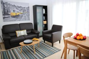 a living room with a black couch and a table at Pine Tree Apartments - Praia da Coelha - Albufeira in Albufeira