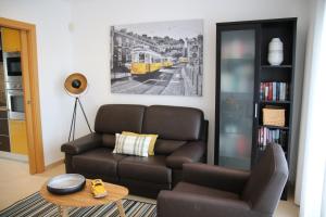 uma sala de estar com um sofá e uma cadeira em Pine Tree Apartments - Praia da Coelha - Albufeira em Albufeira