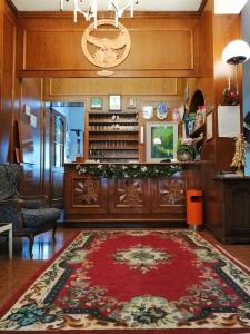 un soggiorno con tappeto rosso sul pavimento di Hotel Aquila & Edelweiss a Camigliatello Silano Altre 37 foto