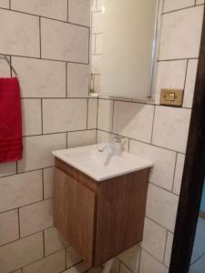 a bathroom with a sink and a mirror at Da Silva Chalé in São Lídio