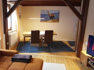 a living room with a table and a horse on the wall at Le Chamois in Sondernach