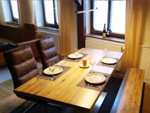 a wooden table with chairs and wine glasses on it at Le Chamois in Sondernach