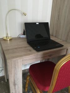 einen Laptop auf einem hölzernen Schreibtisch in der Unterkunft Pension Tannenkopf - Hotel Garni in Bad Soden-Salmünster