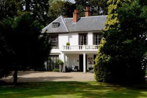 a white house with a balcony and a yard at Satis House Hotel in Yoxford