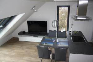een woonkamer met een tafel en een televisie bij Nummer Zwo in Helgoland