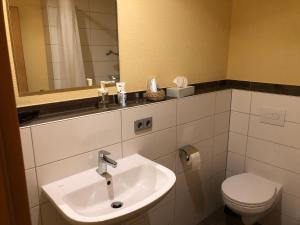 Friederike Wackler Gästehaus في غوبينغِن: حمام مع حوض ومرحاض ومرآة