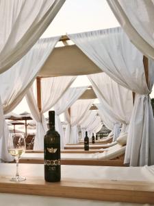 a bottle of wine sitting on a table with a glass at Platy Beach Hotel in Platy