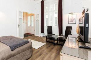 Private Apartment Centertown في بودابست: غرفة نوم بسرير ومكتب مع تلفزيون