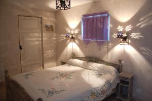 1 dormitorio con cama, ventana y luces en les tilleuls de la voie verte, en Feugarolles