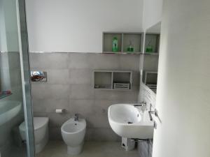 a bathroom with a sink and a toilet at Villa Maria Apartment in Capoterra