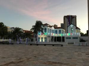 a group of houses with palm trees in front of a city at Apartamento na melhor localização de fortaleza!! in Fortaleza
