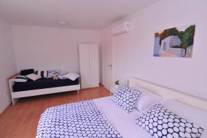 a white bedroom with a bed and a couch at Apartments An Ni in Korčula