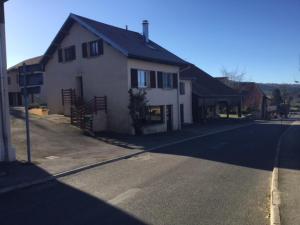 une maison assise sur le côté d'une rue dans l'établissement Gîte Les Montagnes, à Bolandoz