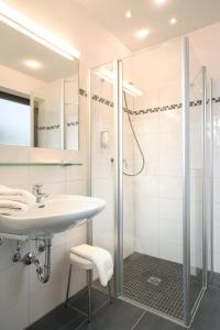 a bathroom with a sink and a shower at Wellness Privathotel Post an der Therme in Badenweiler