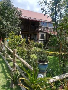 a house with a wooden fence and some plants at Kattekwaad Accommodation in Kaapsehoop