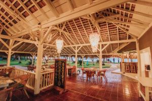 a large wooden pavilion with tables and chairs at El Mosquito Boutique Hotel Playa Bonita in Las Terrenas