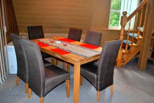 Kirchlinteln的住宿－Heidekäfer Ferienhaus Eichhörnchen，餐桌、椅子和木桌