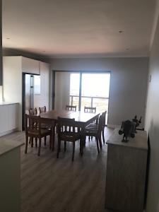 a kitchen and dining room with a table and chairs at Periwinkle Selfcatering 8 in Franskraal