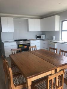 a kitchen with a wooden table and chairs at Periwinkle Selfcatering 8 in Franskraalstrand