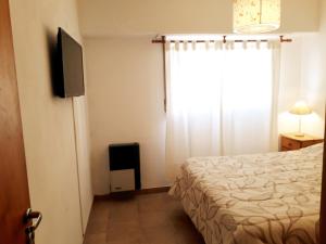 1 dormitorio con 1 cama y TV de pantalla plana en Los Molles en San Clemente del Tuyú