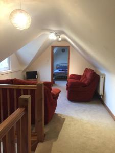 - un salon avec deux chaises rouges et un miroir dans l'établissement Mews Cottage, à Seaford