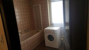 y baño con lavadora y bañera. en Nexis Apartment 10, en Radstadt